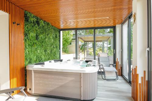 a bathroom with a bath tub and a patio at Kuća za odmor Šumska vila in Duga Resa