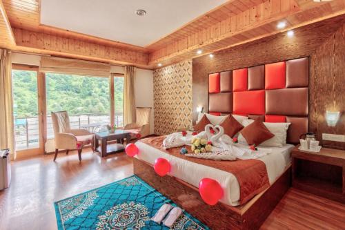 a bedroom with a large bed with a red headboard at Grand Krisa Resort & SPA, Manali Experience Luxury With all Weather ACs in Every Room in Manāli
