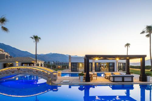 a villa with a swimming pool and a house at Paralia Beachfront Residence in Georgioupolis