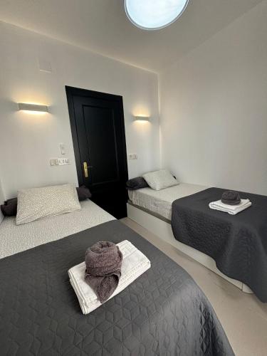 a room with two beds with towels on them at Apartamento Royal Gines I a 10 minutos de Sevilla in Ginés