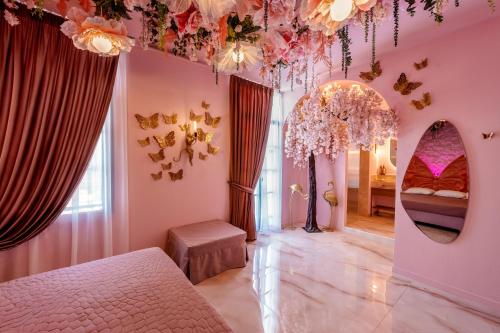 a pink bedroom with a bed and a mirror at Fairytale Athens Suites in Athens