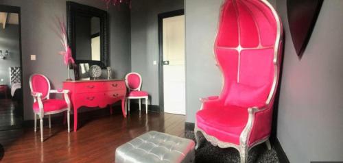 a room with pink chairs and a dresser and a mirror at chateau Laprade Narbonne in Narbonne