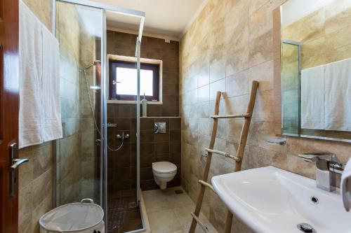 a bathroom with a shower and a sink and a toilet at Paralia Beachfront Residence in Georgioupolis