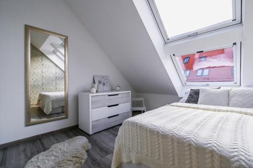 a bedroom with a white bed and a mirror at Luxury City Loft Modern and Elegant in Bratislava