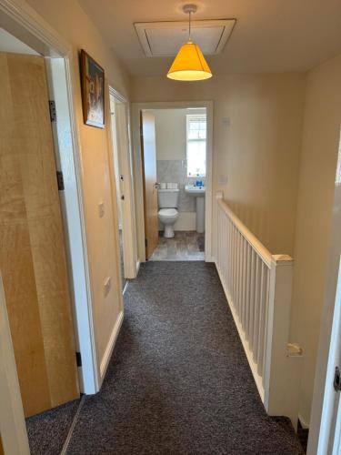 a hallway of a bathroom with a toilet and a sink at Spacious, Sleeps 14, 3 bathrooms, Central, Parking, Grimsby in Grimsby