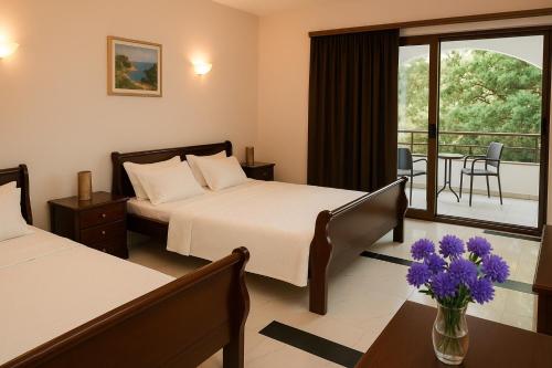 a hotel room with two beds and a table with flowers at Apartments Contessa in Ulcinj