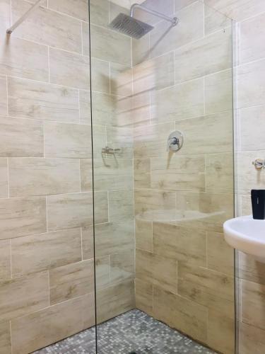 a bathroom with a glass shower with a sink at Blanc and Bold in Kempton Park