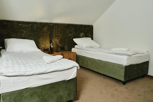 two beds sitting next to each other in a room at Hotel Paola in Kraczkowa