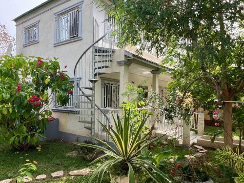 a white house with a staircase in front of it at Mount Pleasant in Brufut