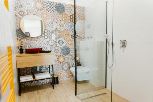 a bathroom with a shower and a sink and a mirror at Ady54 in Tata