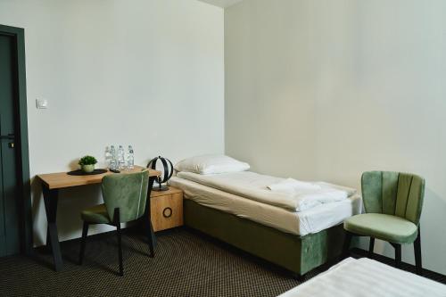 a room with a bed and a table and chairs at Hotel Paola in Kraczkowa