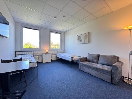 a hospital room with a couch and two beds at Thuja Apartments Karlsruhe-Neureut by KurzZeit in Karlsruhe
