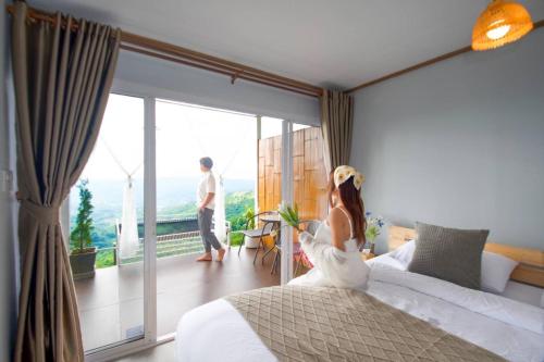 a bride and groom in a hotel room with a balcony at ชิวชิวแคมป์ ภูชี้ฟ้า in Ban Huai Han