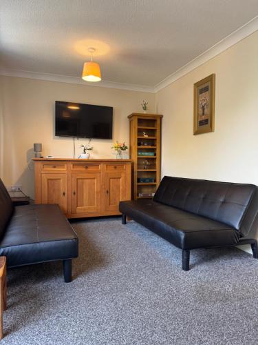 a living room with a couch and a flat screen tv at Spacious, Sleeps 14, 3 bathrooms, Central, Parking, Grimsby in Grimsby