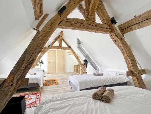 2 letti in una camera con travi in legno di Le Clos de Joux - Charmante Maison en Bourgogne a Joux-la-Ville