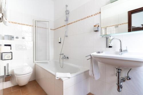 a white bathroom with a sink and a toilet at Hotel zum Ritter in Heidelberg