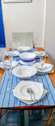 a table with plates and wine glasses on it at Erofili Apartment in Kalyves