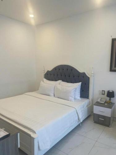 a bedroom with a large bed with white sheets and pillows at White Diamond Airport Hotel in Ho Chi Minh City