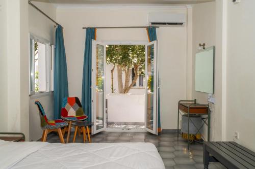 a bedroom with a bed and two chairs and a desk at Albatros Hotel in Karterados