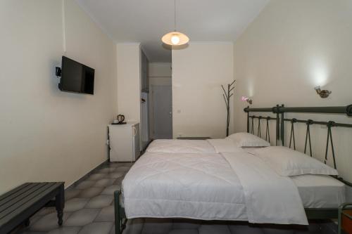 a bedroom with a bed and a tv on the wall at Albatros Hotel in Karterados