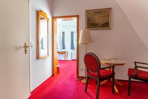 a room with a table and a chair and a desk at Hotel zum Ritter in Heidelberg