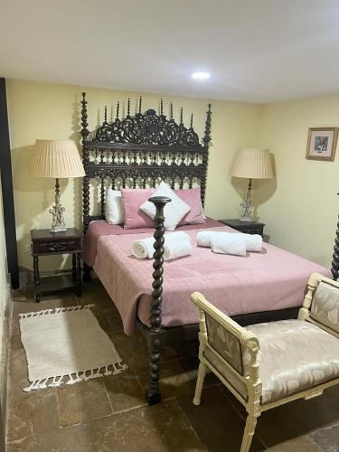 a bedroom with a large bed and a chair at Grand Studio 52 in Faro