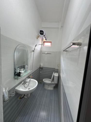 a bathroom with a sink and a toilet and a mirror at Ba Be Lake - Nhà Nghỉ Thư Nhạc in Bak Kan