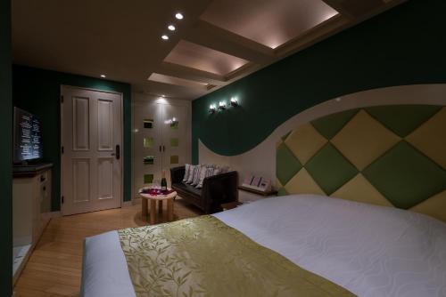 a bedroom with a large bed and a couch at ホテル フェスタ 横須賀 in Yokosuka