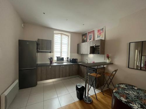 a kitchen with a refrigerator and a table in it at sainte anne petite venise colmar in Colmar
