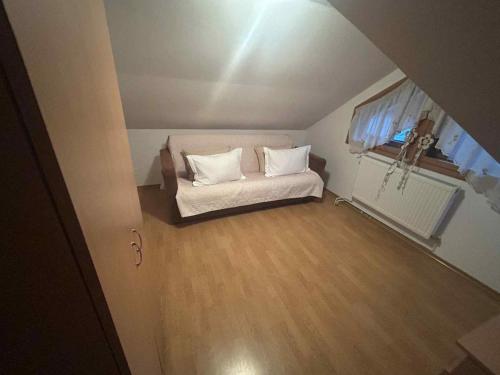 a small room with a white couch and a window at Vila Robert in Slănic-Moldova