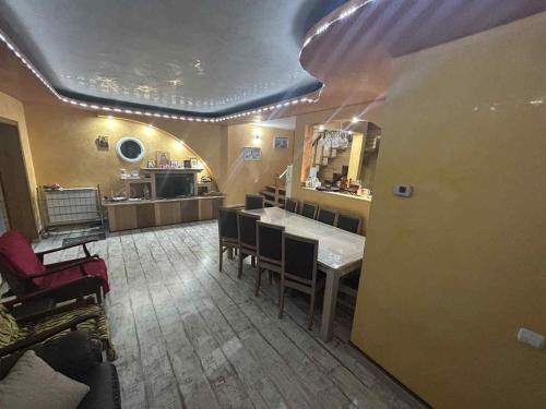 a kitchen with a table and chairs in a room at Vila Robert in Slănic-Moldova