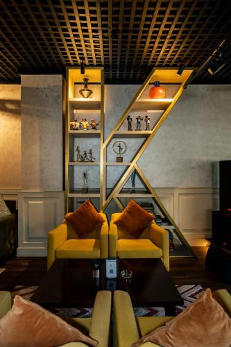 a living room with a yellow couch and a staircase at The K Hotel in Manama