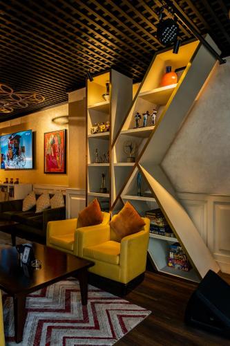 a living room with a yellow couch and a staircase at The K Hotel in Manama