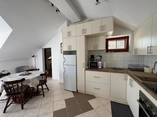 une cuisine avec une table et un réfrigérateur blanc dans l'établissement Apartment Sea Dance, Korcula town, à Korčula