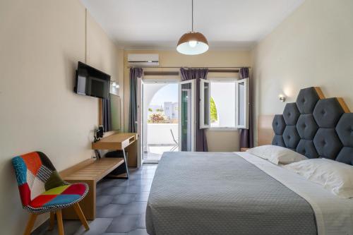 a bedroom with a bed and a chair and a desk at Albatros Hotel in Karterados