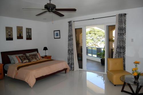 a bedroom with a bed and a ceiling fan at viri Home in Panglao