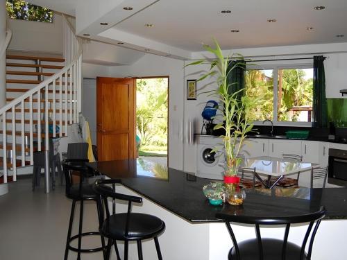 a kitchen with a black counter top and chairs at viri Home in Panglao