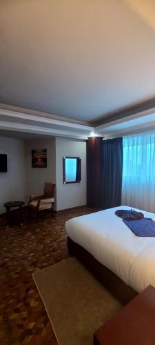 a hotel room with a large bed and a couch at Omedad Hotel in Dirē Kʼalu