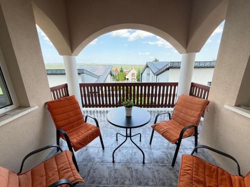 a balcony with a table and chairs and a view at Voyage Apartments in Hévíz