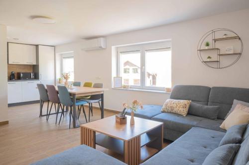 a living room with a couch and a table at Vila Jelena - modern spacious apartments near Vintgar Gorge & Bled in Zgornje Gorje