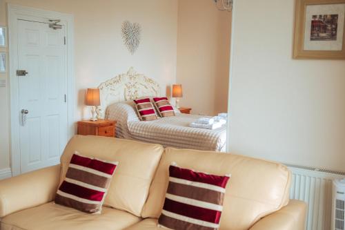 a living room with a couch and a bed at Plas Gorwelion guest house - Adult only in Llandudno