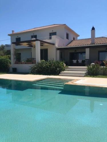 a house with a swimming pool in front of a house at Ira Private Villa with Pool in Tragaki