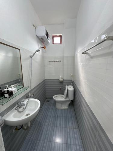 a bathroom with a sink and a toilet and a mirror at Ba Be Lake - Nhà Nghỉ Thư Nhạc in Bak Kan