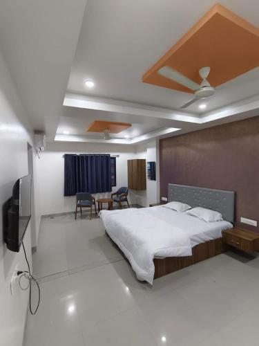 a bedroom with a large bed and a television at Mauli executive restaurant in Aurangabad