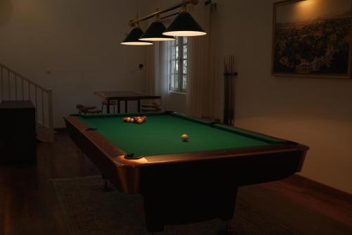 a pool table in a living room with afits at Villa Dhūmragiri in Maskeliya