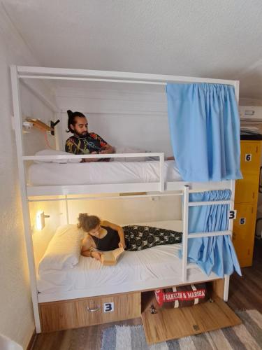 Dos personas en literas en una habitación. en Hostel El Cascabel, en Granada