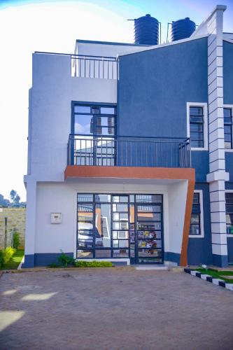 a large blue and white building with a balcony at Anada Estate, Gikambura, Thogoto, Kikuyu, Kiambu County in Nairobi