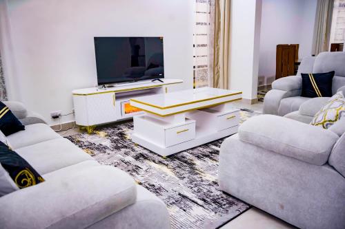 a living room with two couches and a tv at Anada Estate, Gikambura, Thogoto, Kikuyu, Kiambu County in Nairobi