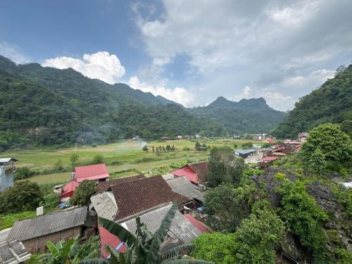 a small village with mountains in the background at Ba Be Lake - Nhà Nghỉ Thư Nhạc in Bak Kan