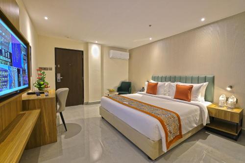 a bedroom with a large bed and a flat screen tv at Hotel Grand Continent Premiere, Banjara Hills, Hyderabad in Hyderabad